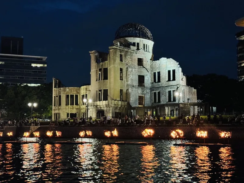 廣島原爆80週年前夕，市民團體在原爆圓頂館旁的元安川舉辦篝火點燈儀式，表達對世界和平的祝願。中央社