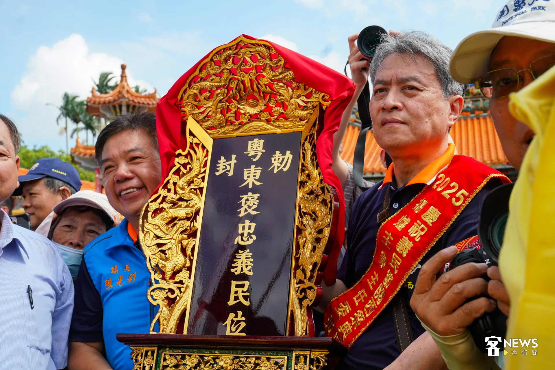 總爐主羅吉平（右）與關西鎮長陳光彩（左）將義民爺牌位請上神轎。洪藝晅攝