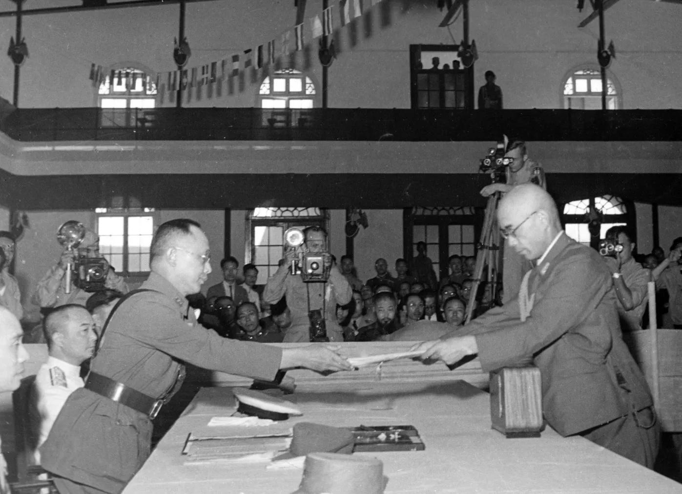 1945年9月9日南京受降典禮，在華日軍總參謀長小林淺三郎（右）遞交降書給國民政府陸軍總令何應欽將軍。公有領域
