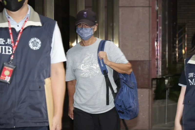 北檢25日指揮調查局台北市調處，兵分3路搜索被告教練周台英（灰衣）住居所及辦公室並約談周台英，另通知涉案教師陳忠慶等4名證人到案，朝詐欺、侵占等罪偵辦。晚間11時將周台英移送北檢複訊。中央社