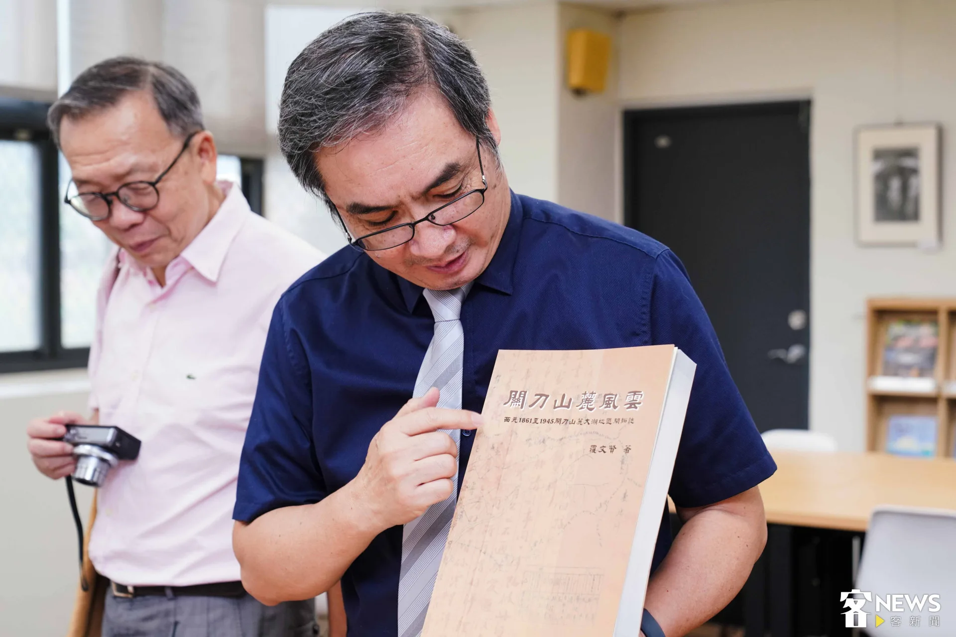 客傳會董事長陳邦畛（右）介紹書展書籍。朱愷元攝