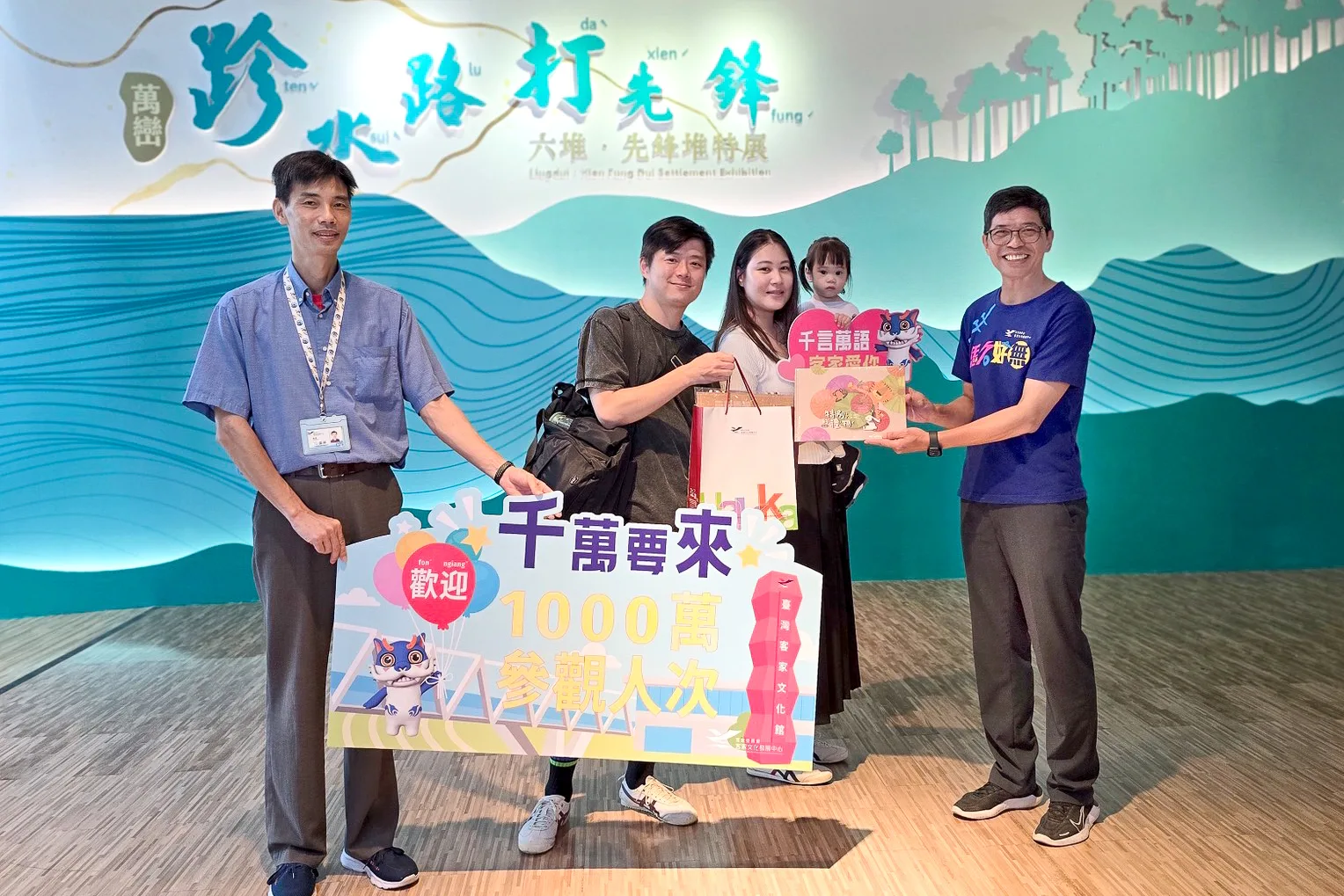 何金樑(右1)與臺灣客家文化館第1000萬參觀遊客合影,並致贈小禮物。客發中心提供