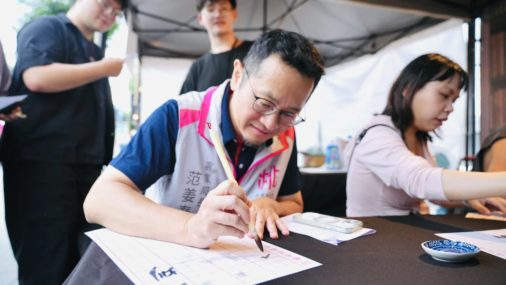 客家局長范姜泰基現場體驗書法活動，揮毫感受傳統文化魅力。桃園市政府提供