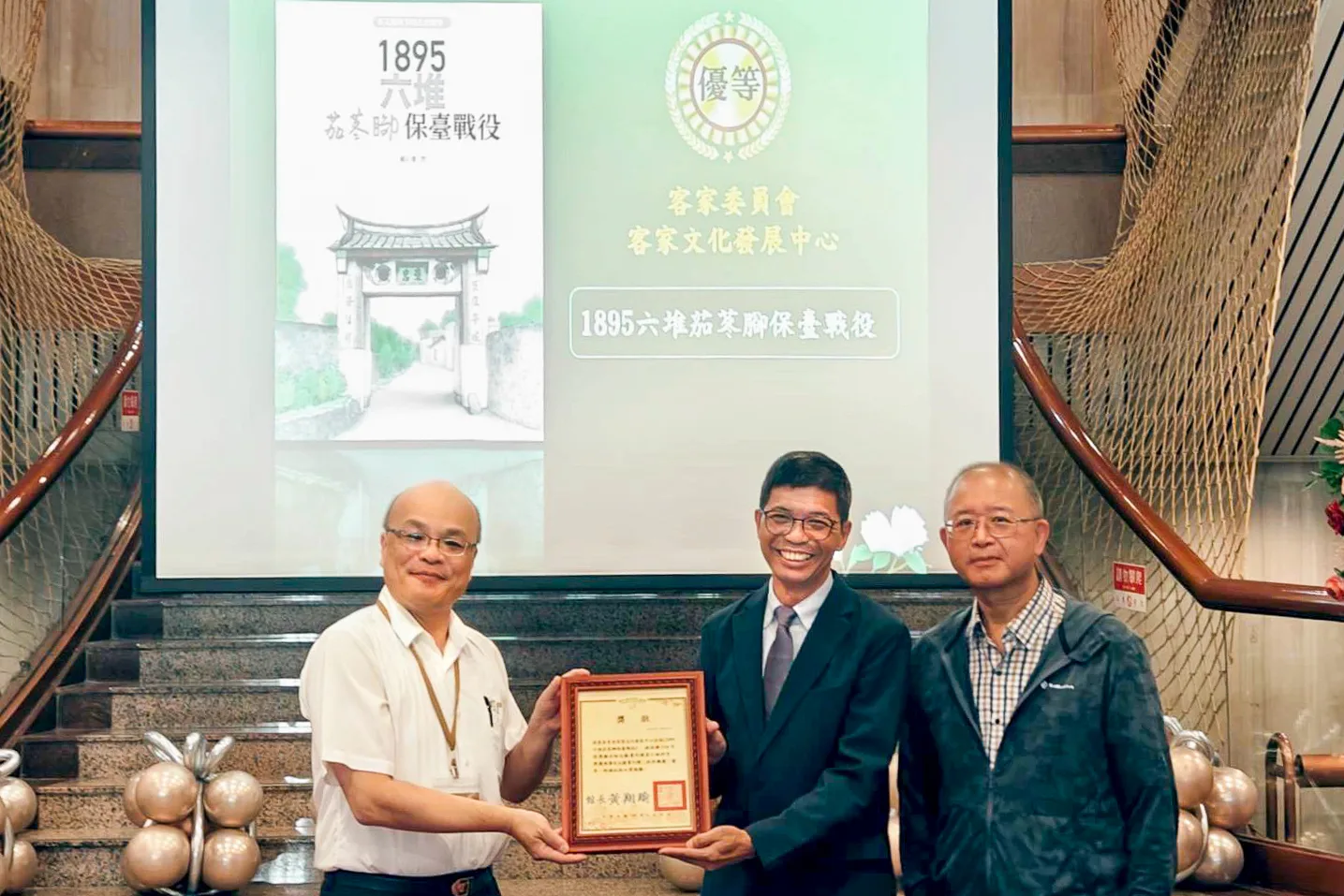 臺灣文獻館館長黃翔瑜頒發獎章予客發中心主任何金樑。客發中心提供