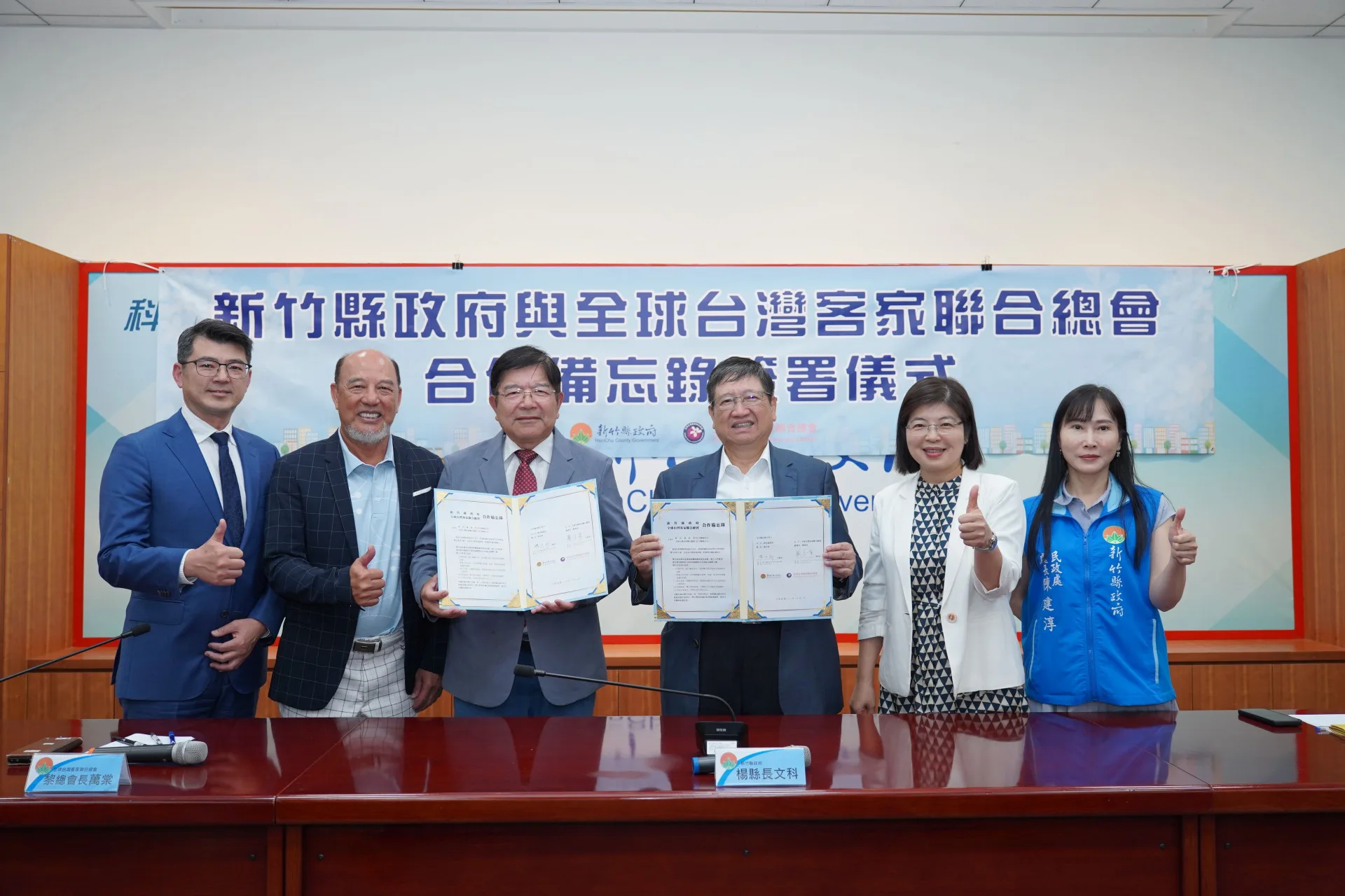 新竹縣長楊文科與全球台灣客家聯合總會長黎萬棠，今天在竹縣府簡報室，共同簽署合作備忘錄。竹縣府提供
