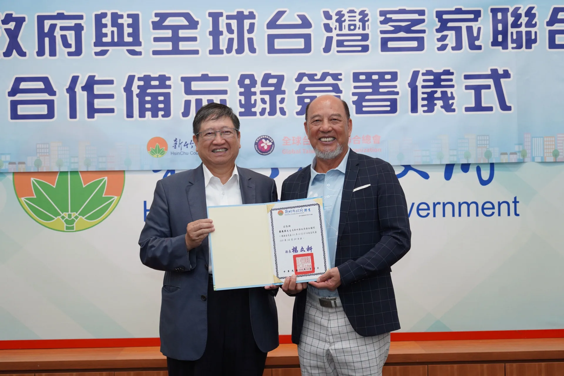 新竹縣長楊文科（左)頒發縣政顧問聘書給葉義深(右），感謝他於2023年2月促成全球台灣客家聯合總會成立。