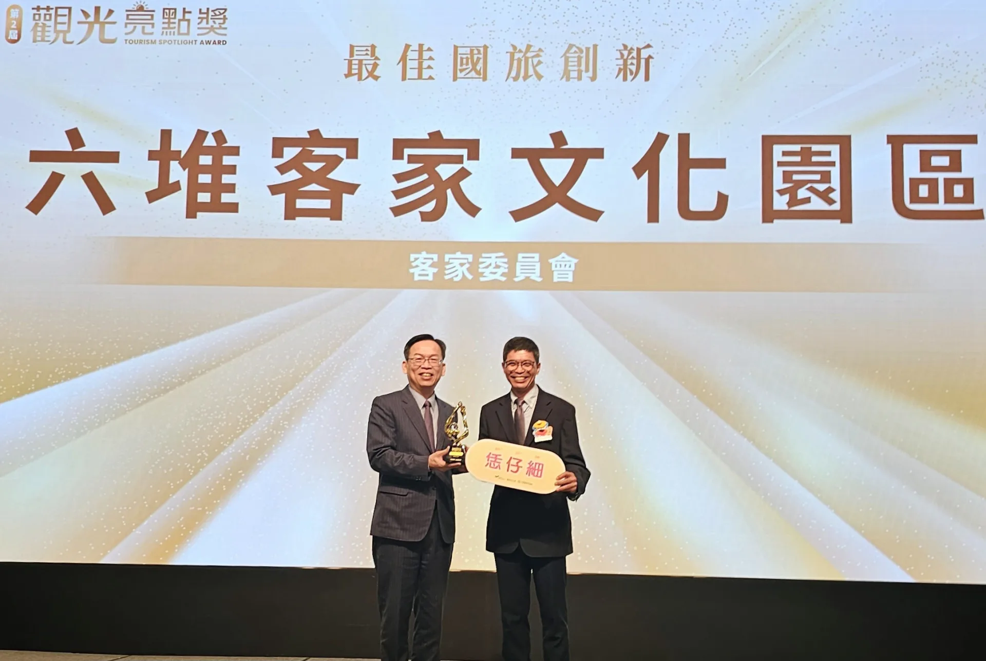 客發中心主任何金樑(右)上台受頒六堆客家文化園區「最佳國旅創新獎」。客委會提供