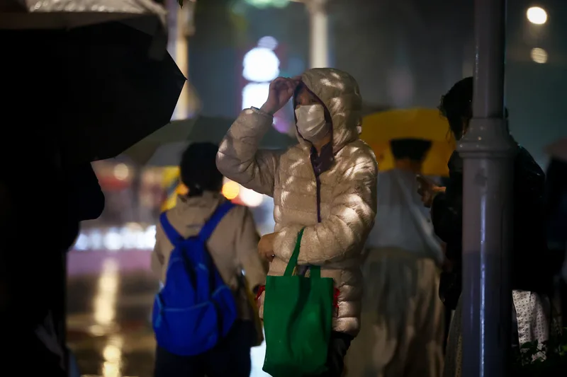 受東北季風影響，新北市板橋區17日午後轉為有雨的天氣，入夜氣溫降低，街頭民眾穿上羽絨外套禦寒。中央社