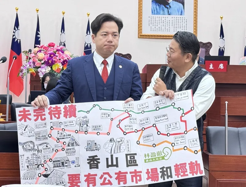 新竹市議員林盈徹(右)20日在議會總質詢時,將手繪的「香山版」輕軌地圖贈予代理市長邱臣遠(左),盼市府能將新竹輕軌延伸至香山區。中央社