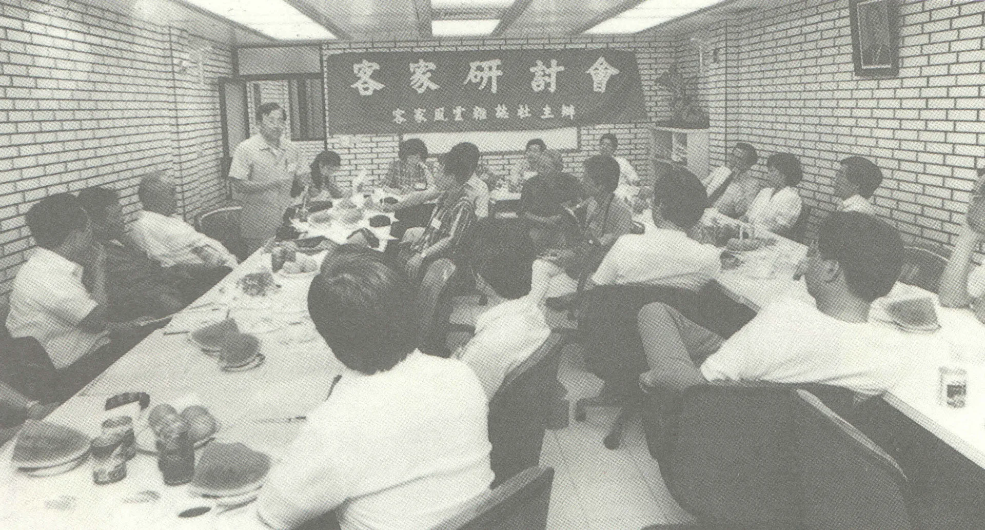 這個會叫做「台灣四十年來客家研究第一次大集結」的客家研討會,討論客家學的建立。1989年5月21日星期日,在台北市徐綜合醫院三樓會議室。林一雄老師是主辦單位《客家風雲》雜誌代表(右前方坐在第一位置),站立發言的是陳運棟校長(客家研究學者),這張照片大約有一半的人已經成仙了,另外吊在右邊牆上的照片就是我們的少棒之父徐傍興博士。1989,台北,楊國鑫提供