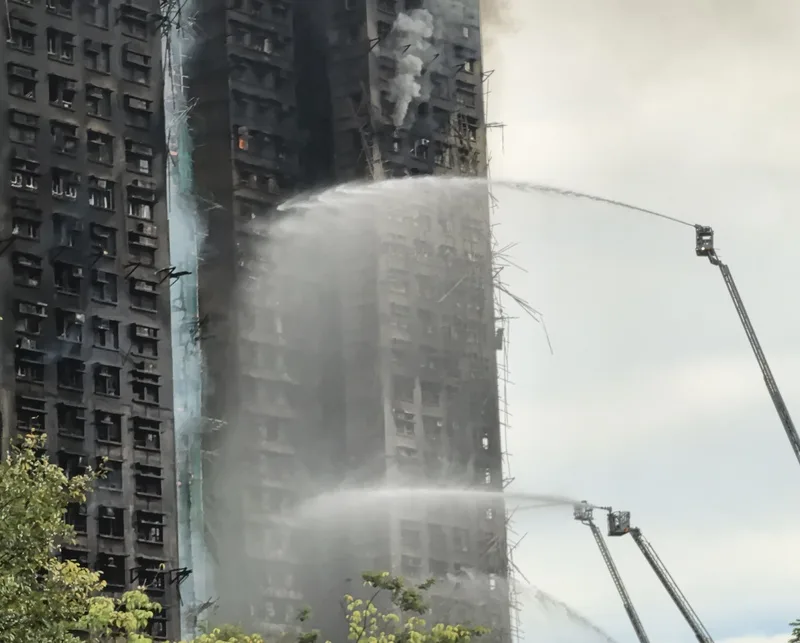 香港大埔宏福苑大火，自26日下午焚燒至今，圖為27日早上10時，消防員向大樓射水。中央社