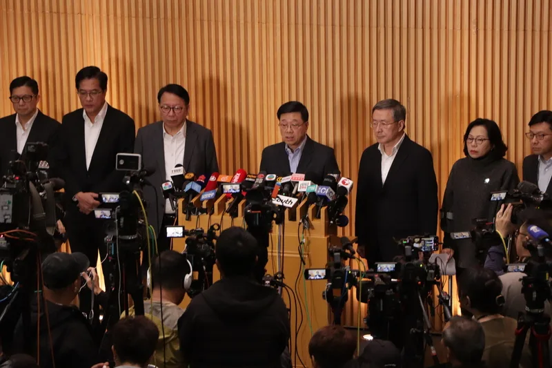 香港行政長官李家超（後排中間）27日率同主要官員說明大埔宏福苑大火。中央社
