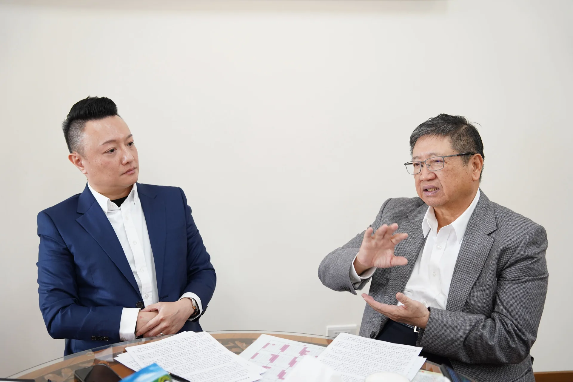 新上任的數發處長劉奕帆（左）向楊文科縣長（右）說明「AI 縣民管家」。新竹縣政府提供