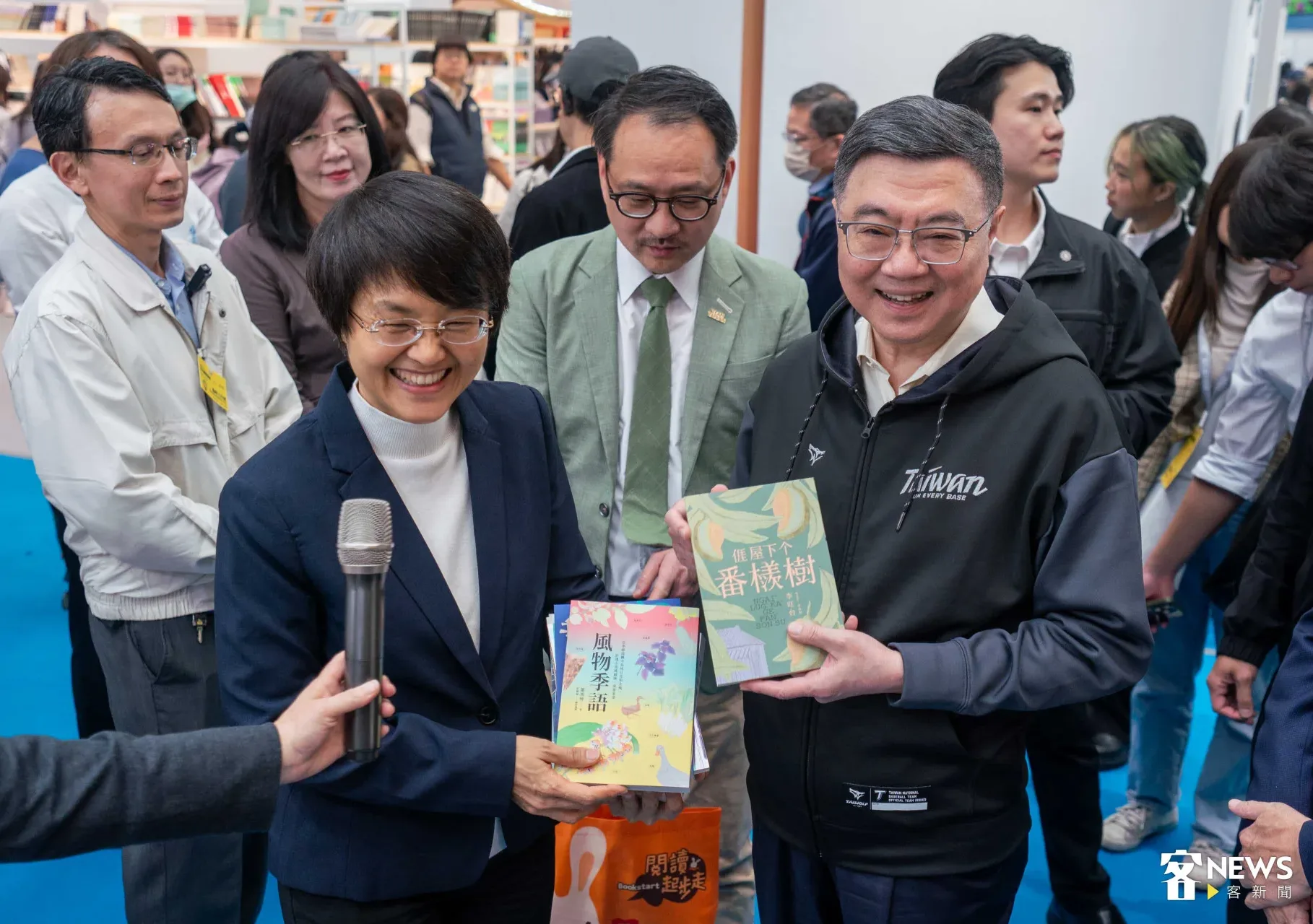 卓榮泰、古秀妃拿著《風物季語》及《𠊎屋下个番檨樹》合影留念。范修語攝