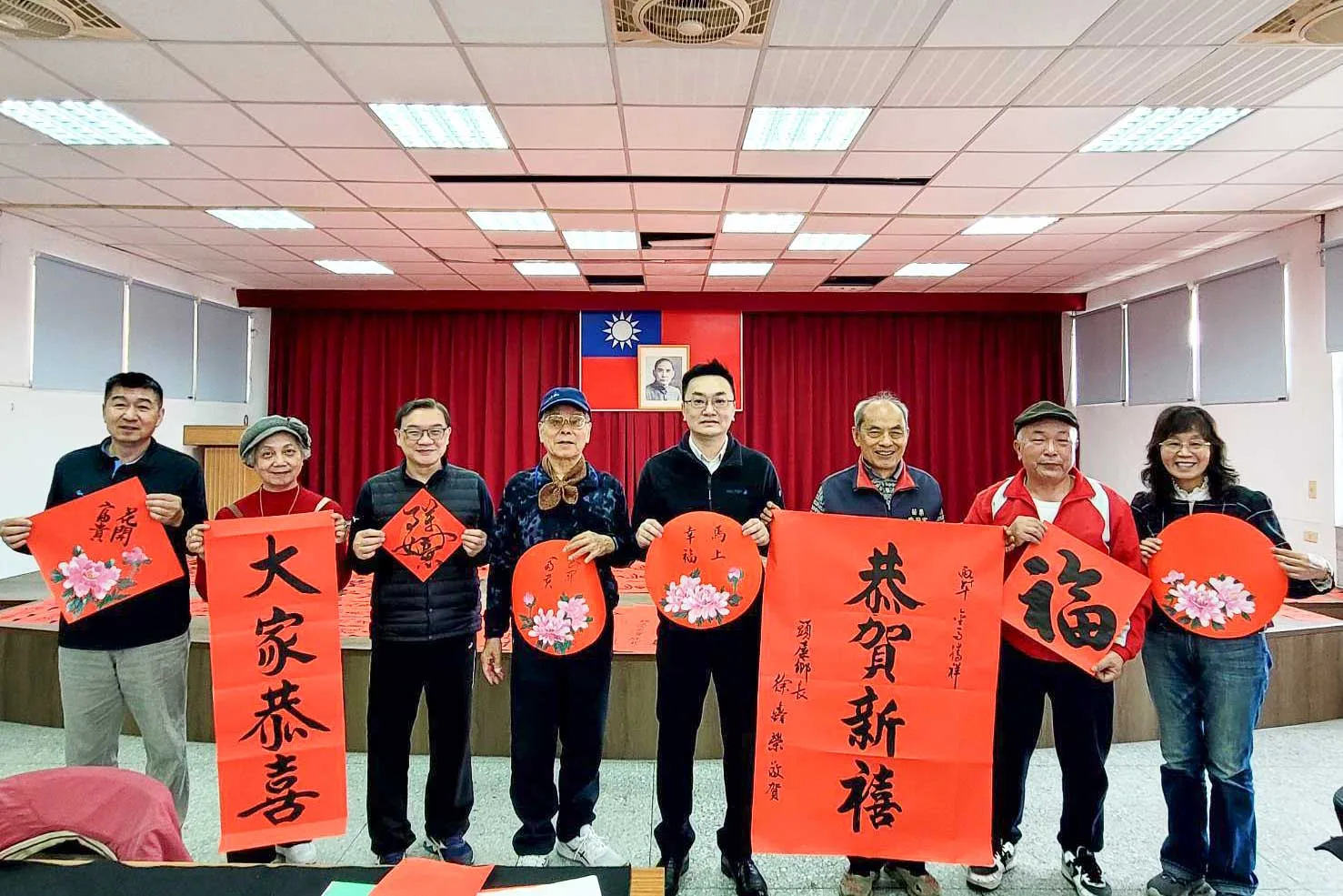 頭屋象山書院書法老師春節前到頭屋鄉公所寫春聯，向鄉民們賀年。左起劉安彬、杜琦琴、韋郁群、徐清明、彭鈞誌、楊政男、饒明鋒、葉玉玲。饒明鋒提供