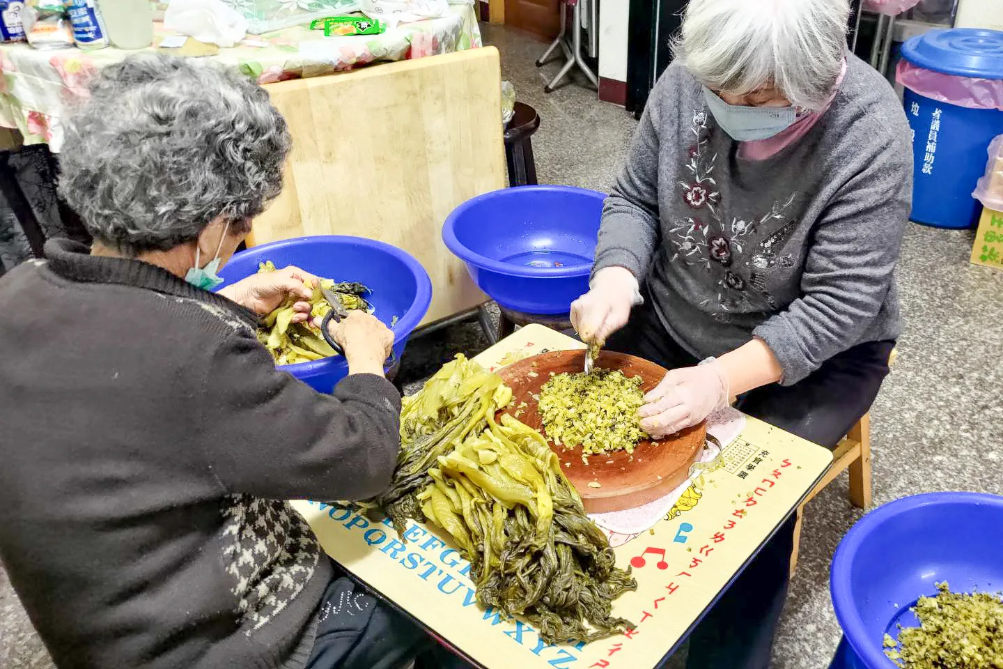 鳳嬌米食王師傅表示,今年老鄰居阿姨自己醃了一批酸菜,色澤呈現金黃色,香氣十足,和她買來做酸菜口味的菜包。王湘仁攝)