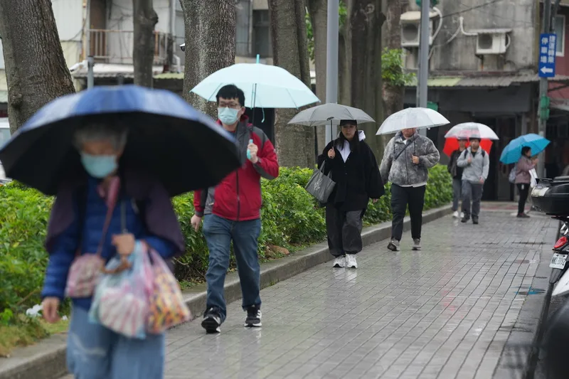 日受華南雲雨區影響，各地都可能有短暫降雨，上半天降雨較明顯。台北市北投區街道上，民眾紛紛撐傘避雨。中央社