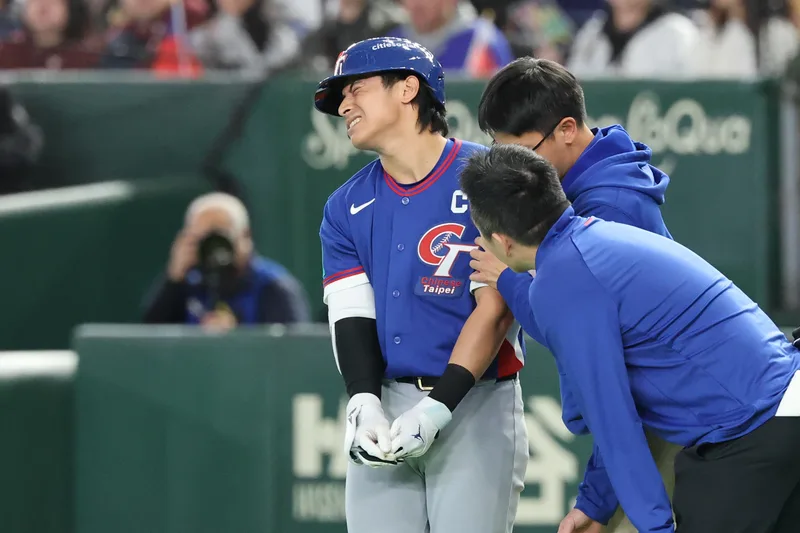 世界棒球經典賽(WBC)C組預賽5日在日本東京巨蛋開打,首戰由台灣隊迎戰澳洲隊。6局上台灣隊長陳傑憲(左)遭觸身球擊中手部,表情痛苦。中央社