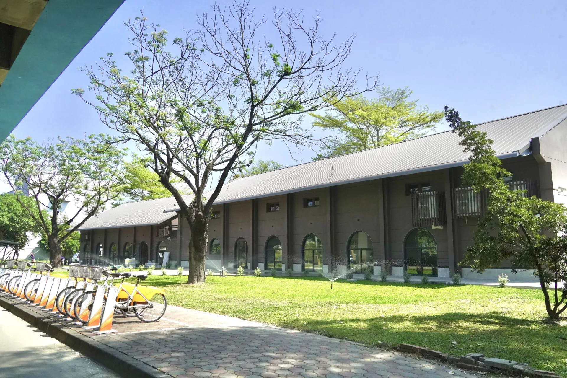 屏東縣政府以「好客・舒活・慢慢走」為核心理念，活化台鐵舊有一號倉庫（右）、二號倉庫（左），融合客家元素、日式生活美學與在地特色餐飲，打造具有展演、餐飲與背包客旅宿等多功能場域。屏東縣政府提供