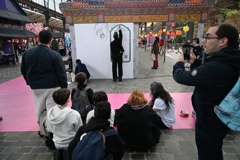 艾莉柚與藥島在布魯塞爾書展會場合作創作漫畫，吸引許多民眾圍觀、拍攝。中央社