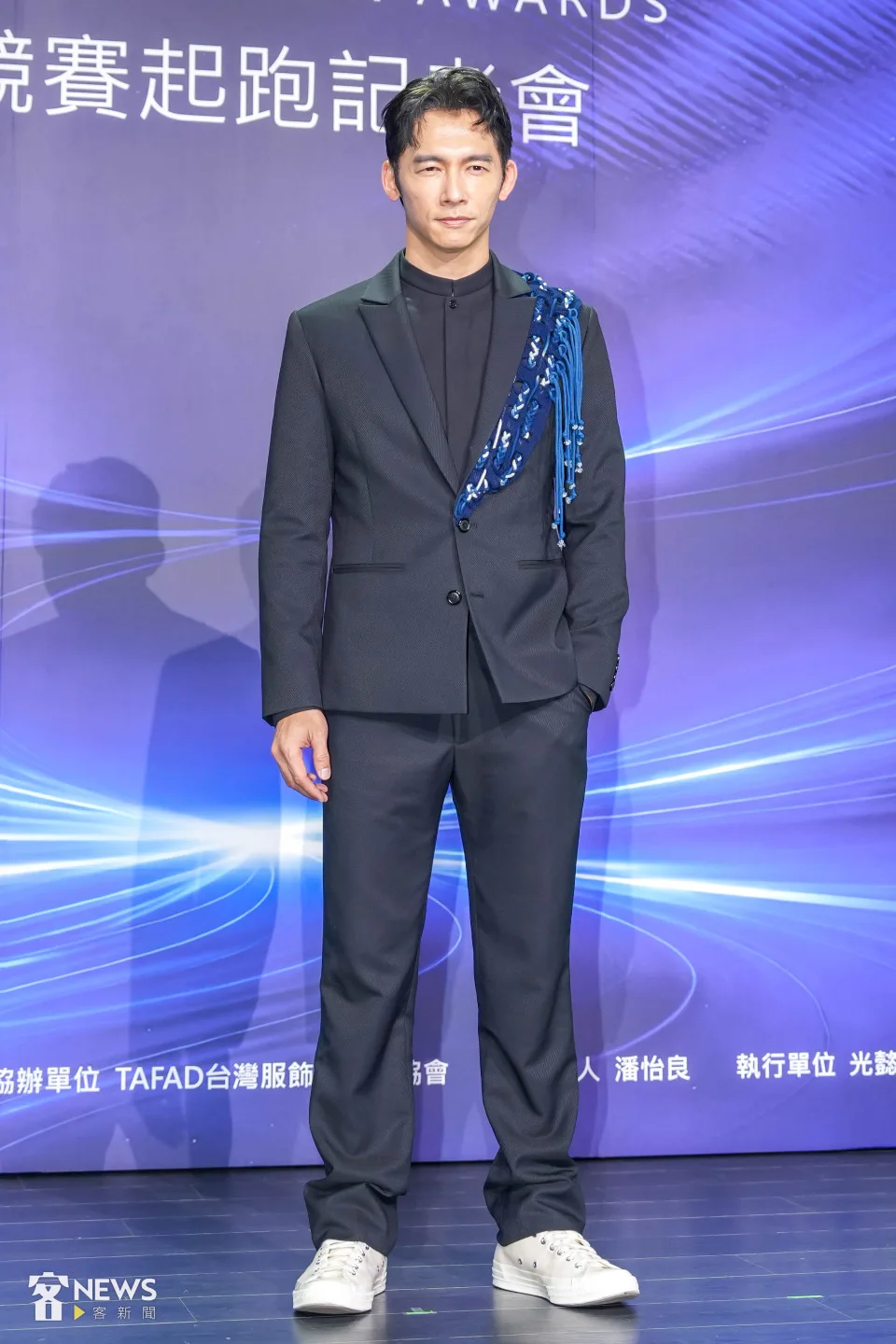 温昇豪身穿俐落剪裁深色西裝,外套左半邊透過藍染織布以及編織線條裝飾,打破既有客家花布印象。李台源攝