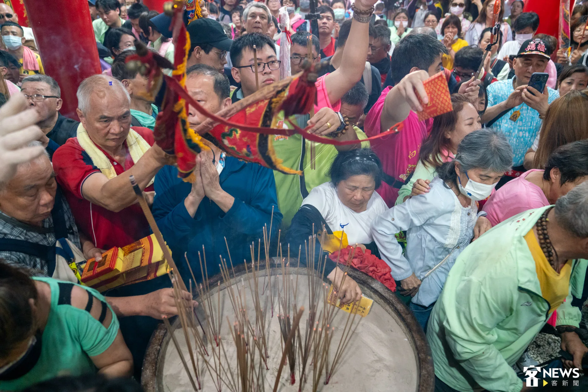 許多香燈腳拿著物品過香爐,祈求媽祖庇佑。范修語攝
