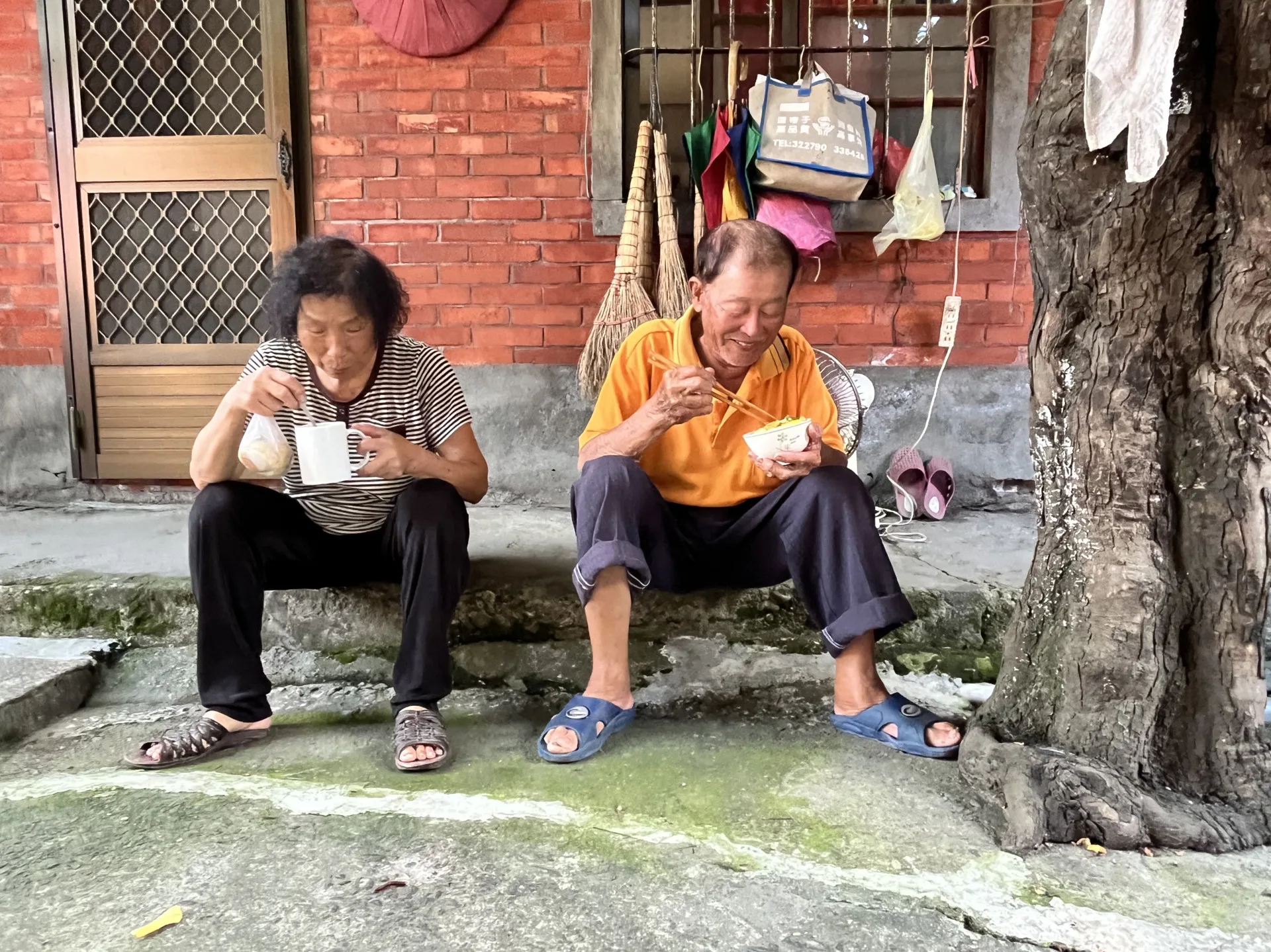 黃顯明與蘇秀鳳夫婦在老屋外悠閒享用早餐，充滿怡然自得的幸福感。徐彩雲攝