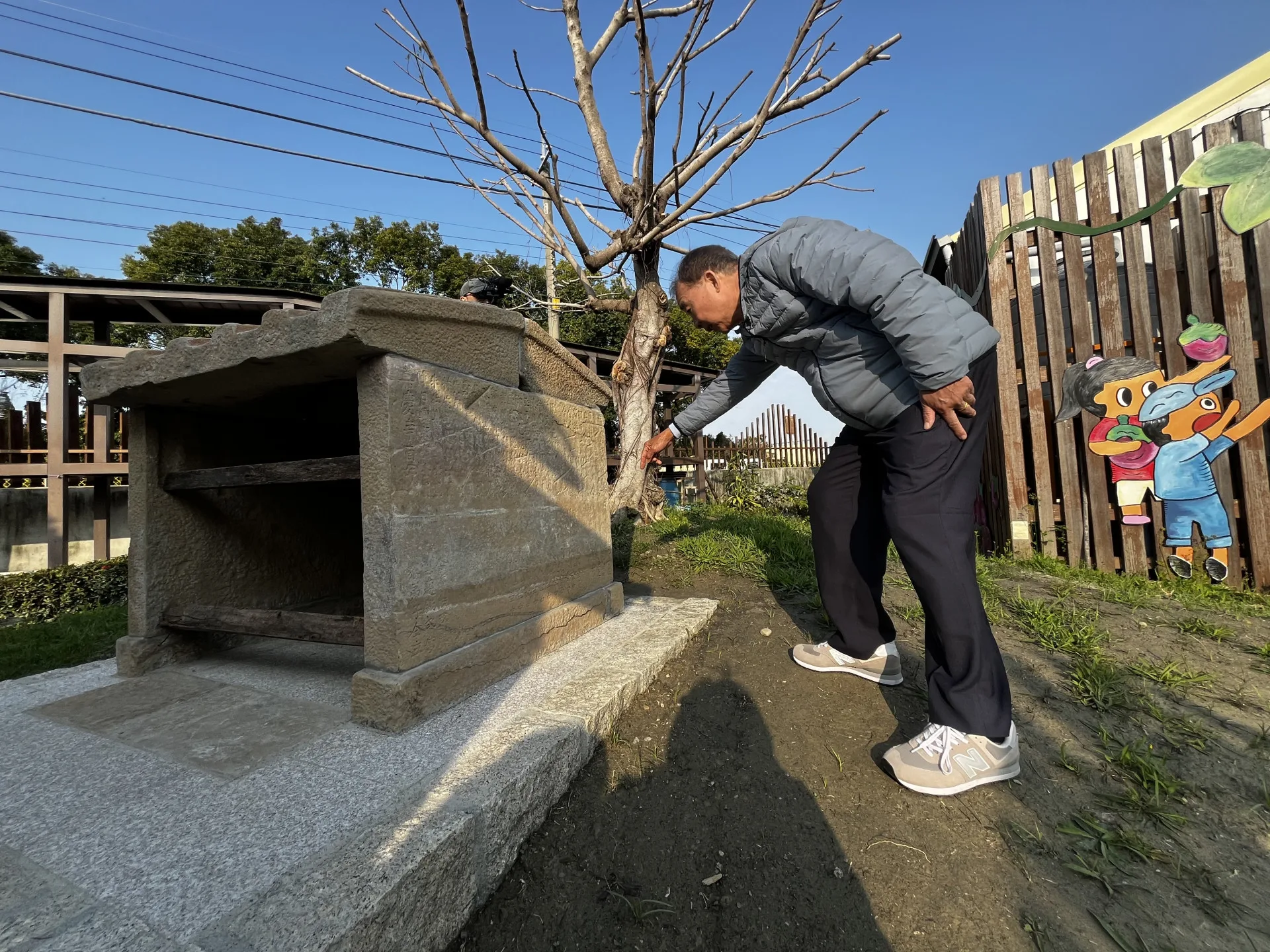 黃世昌村長指著意外出土的嘉慶辛酉年（1801 年）石碑，見證土地公廟的悠久歷史。徐彩雲攝