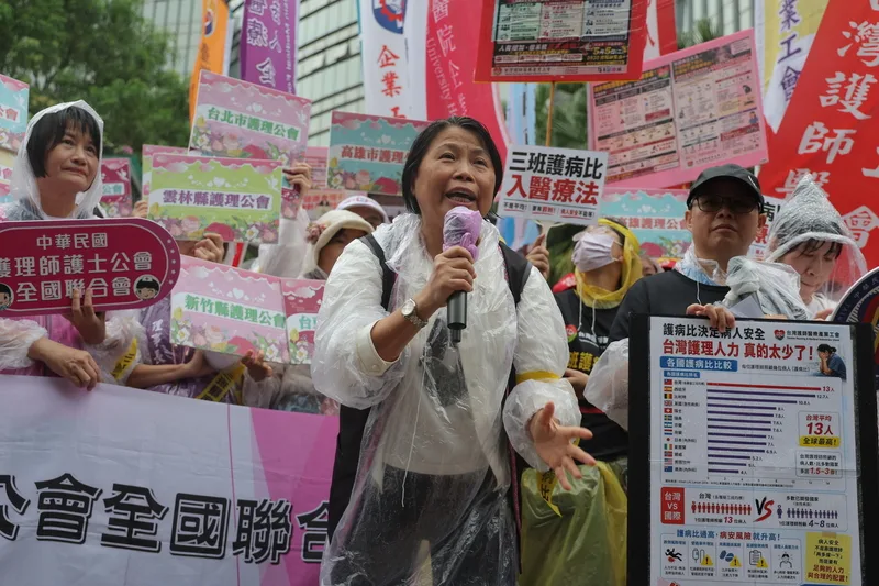 護理師護士公會全國聯合會、台灣護理產業工會「護理三班護病比法制化」行動5日上午於衛福部前舉行，中華民國護理師護士公會全國聯合會理事長陳麗琴（前）致詞說明現今護理師困境，並呼籲政府重視。中央社