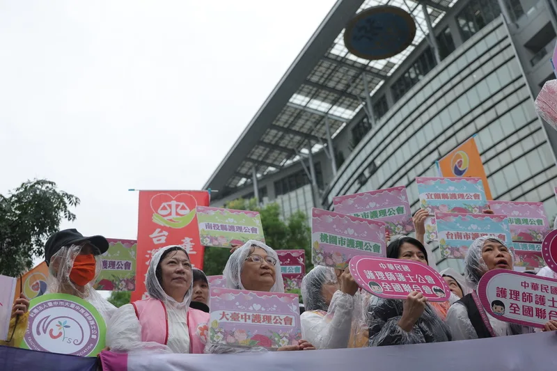 護理師護士公會全國聯合會、台灣護理產業工會5日上午動員至衛福部前抗議，現場下著大雨，護理人員身穿雨衣、手拿看板表達訴求，爭取三班護病比入法。中央社