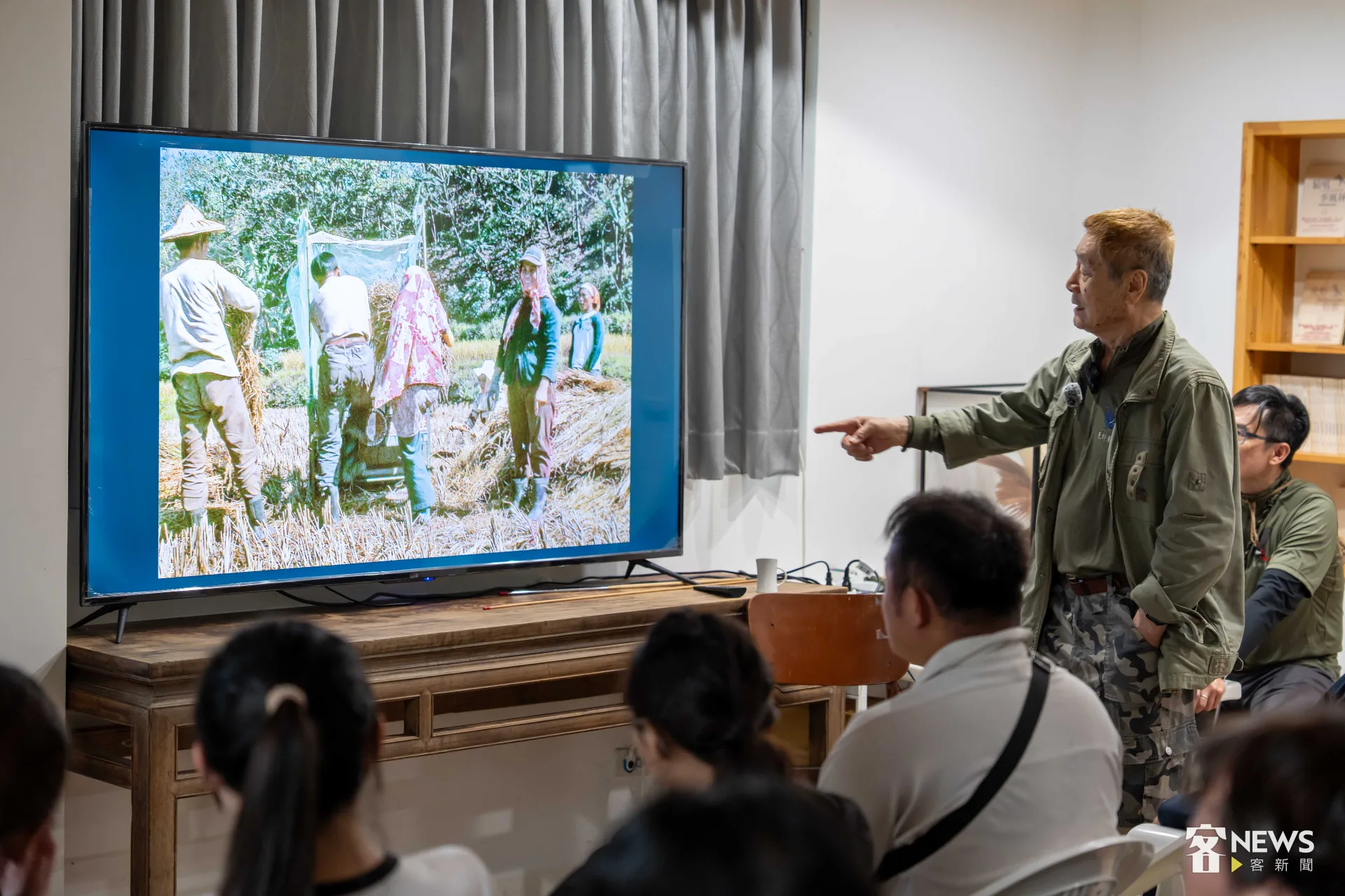 徐仁修展示過去農村割稻的照片，圖中脫榖機的動力是用人工腳踩產生。朱愷元攝