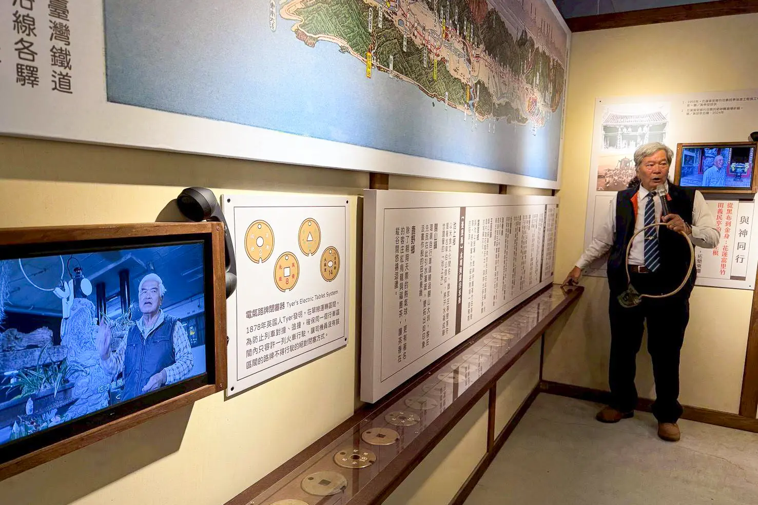 「花東鐵路百年通車-鐵定有客特展」28面電氣路牌首次同時公開亮相，圖為客家鐵路人張建忠解說。客發中心提供