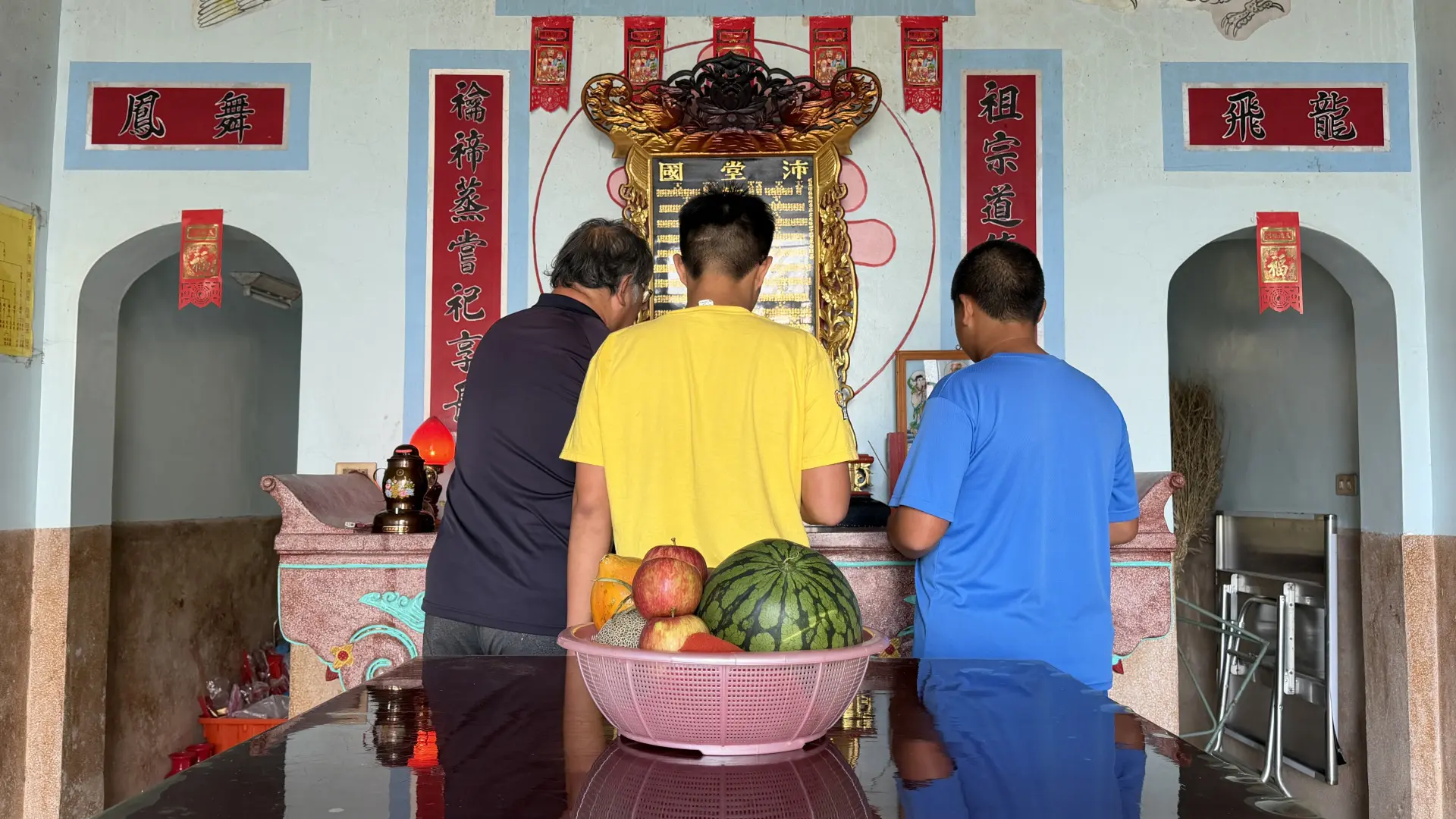 爸爸向兄弟倆解釋上香祭拜的順序。李慧宜攝