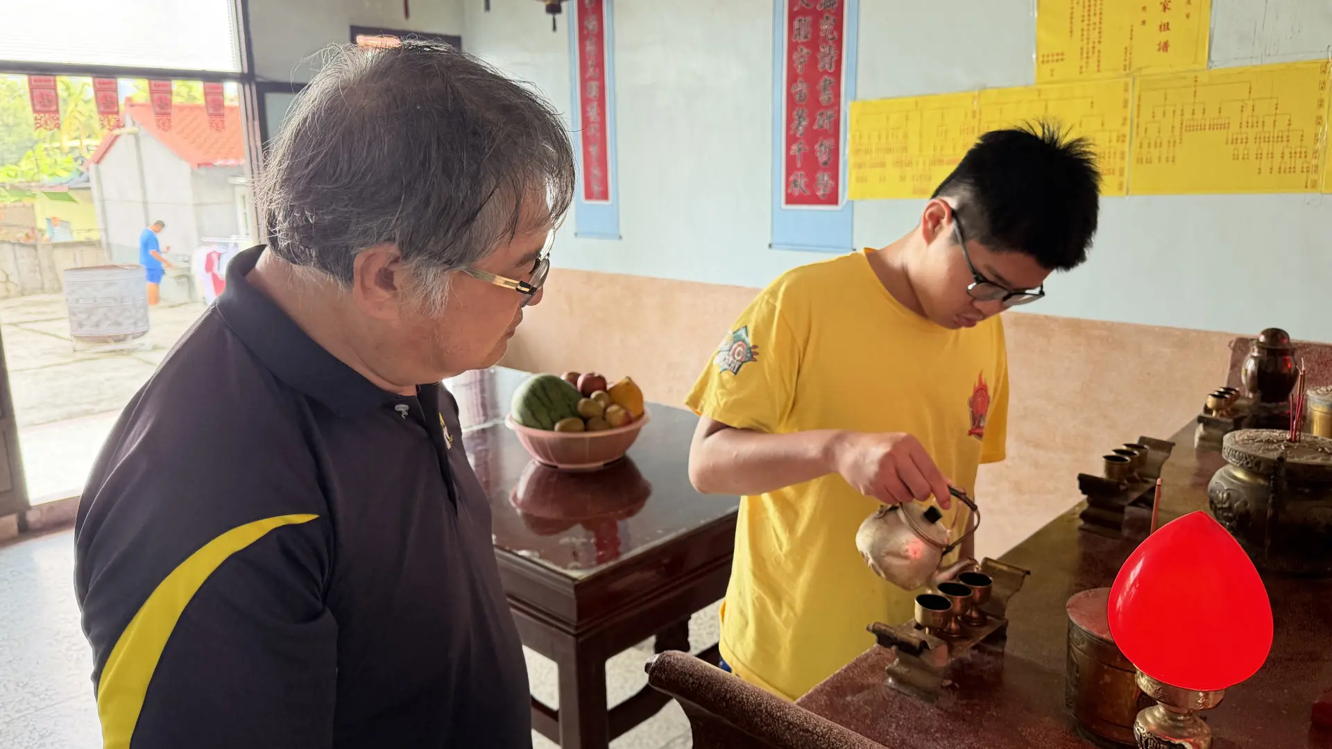哥哥為祖先斟茶。李慧宜攝