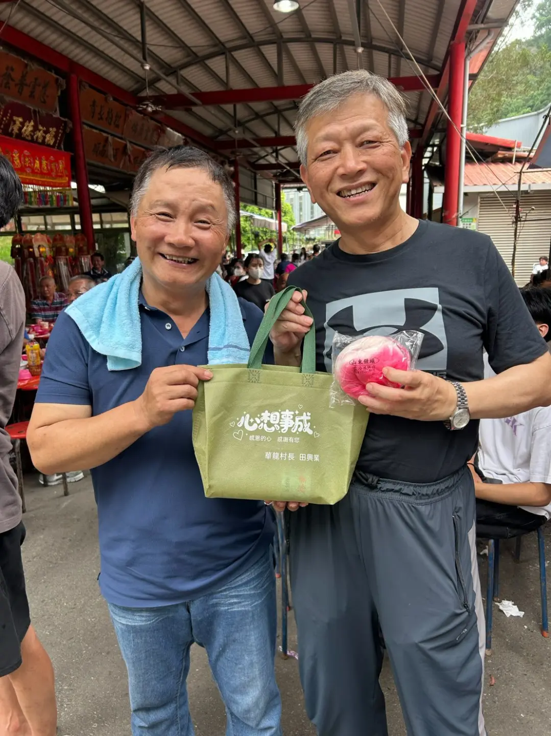 我依約前往芎林鄉鹿寮坑參加圓石伯公的食伯公福，村長田興業(左)還加碼送我一個壽桃。2026，芎林鄉鹿寮坑。楊國鑫提供
