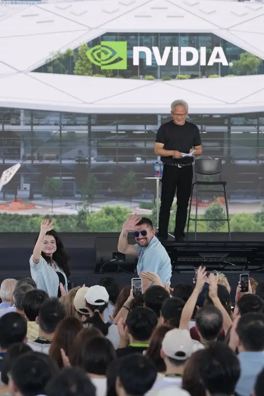 人工智慧(AI)晶片大廠輝達(NVIDIA)27日在台灣新總部預定地北士科T17、18舉辦台灣員工大會,執行長黃仁勳(後)的一對兒女(前立者)也到場共襄盛舉,向員工們揮手致意。中央社
