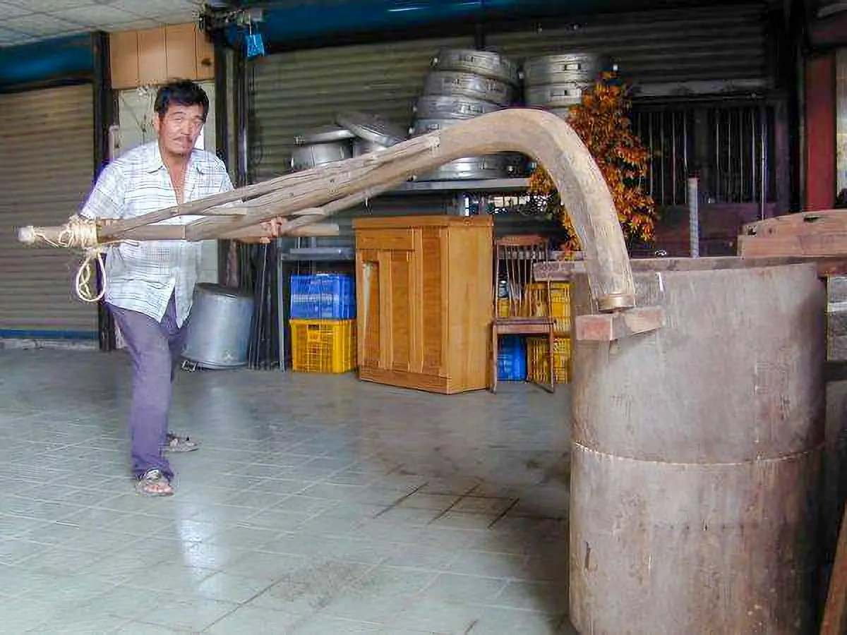 新埔文史工作者劉邦賢在「挨礱」,他跟洪惠冠的「挨粄」不一樣,這個叫「礱」的器具是將稻穀的外皮剝去。這個「礱」是木頭做的。陳權欣攝