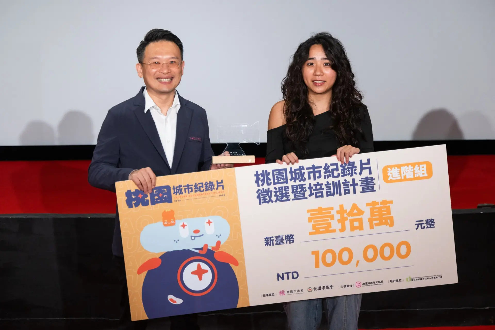 陳聖心以《婆娑》榮獲進階組首獎及獎金10萬元,她從桃園市副市長蘇俊賓(左)接下獲獎獎金。翻攝紀錄桃園FB
