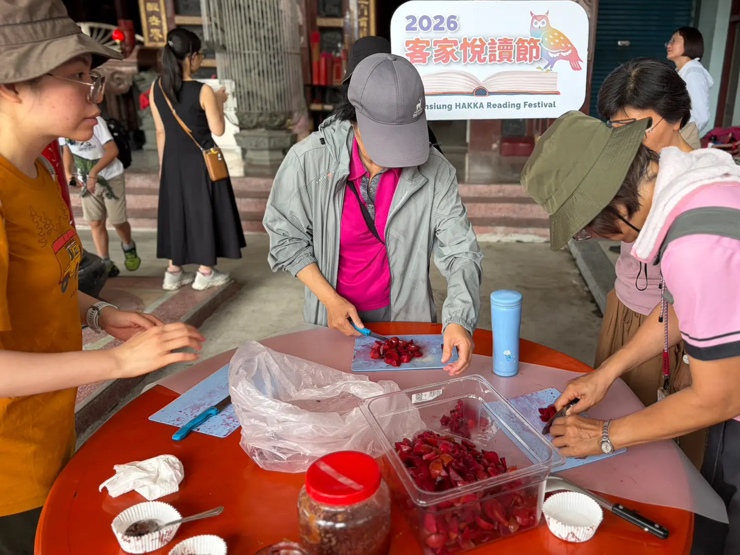 團員在宣化堂前製作與品嚐來自那瑪夏微酸帶甜的紅肉李果醬。高雄客基會提供