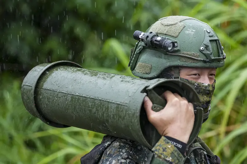 陸軍第十軍團9日在台中大甲溪出海口周邊實施重砲射擊暨新式武器換裝驗證射擊訓練，官兵冒雨搬運彈藥及相關裝備。中央社