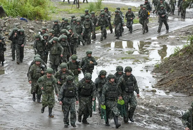 陸軍第十軍團9日在台中大甲溪出海口周邊實施重砲射擊暨新式武器換裝驗證射擊訓練，任務結束後，官兵在雨中集結撤離射擊陣地。中央社