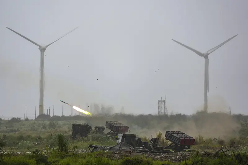 陸軍第十軍團9日在台中大甲溪出海口周邊實施重砲射擊暨新式武器換裝驗證射擊訓練，雷霆2000多管火箭系統發射火箭彈，與遠方風力發電機組相映。<br />中央社