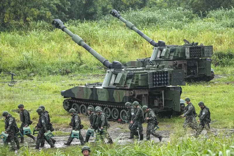 陸軍第十軍團9日在台中大甲溪出海口周邊實施重砲射擊暨新式武器換裝驗證射擊訓練，任務結束後，官兵攜帶裝備離開射擊陣地，後方為M109A2自走砲。中央社