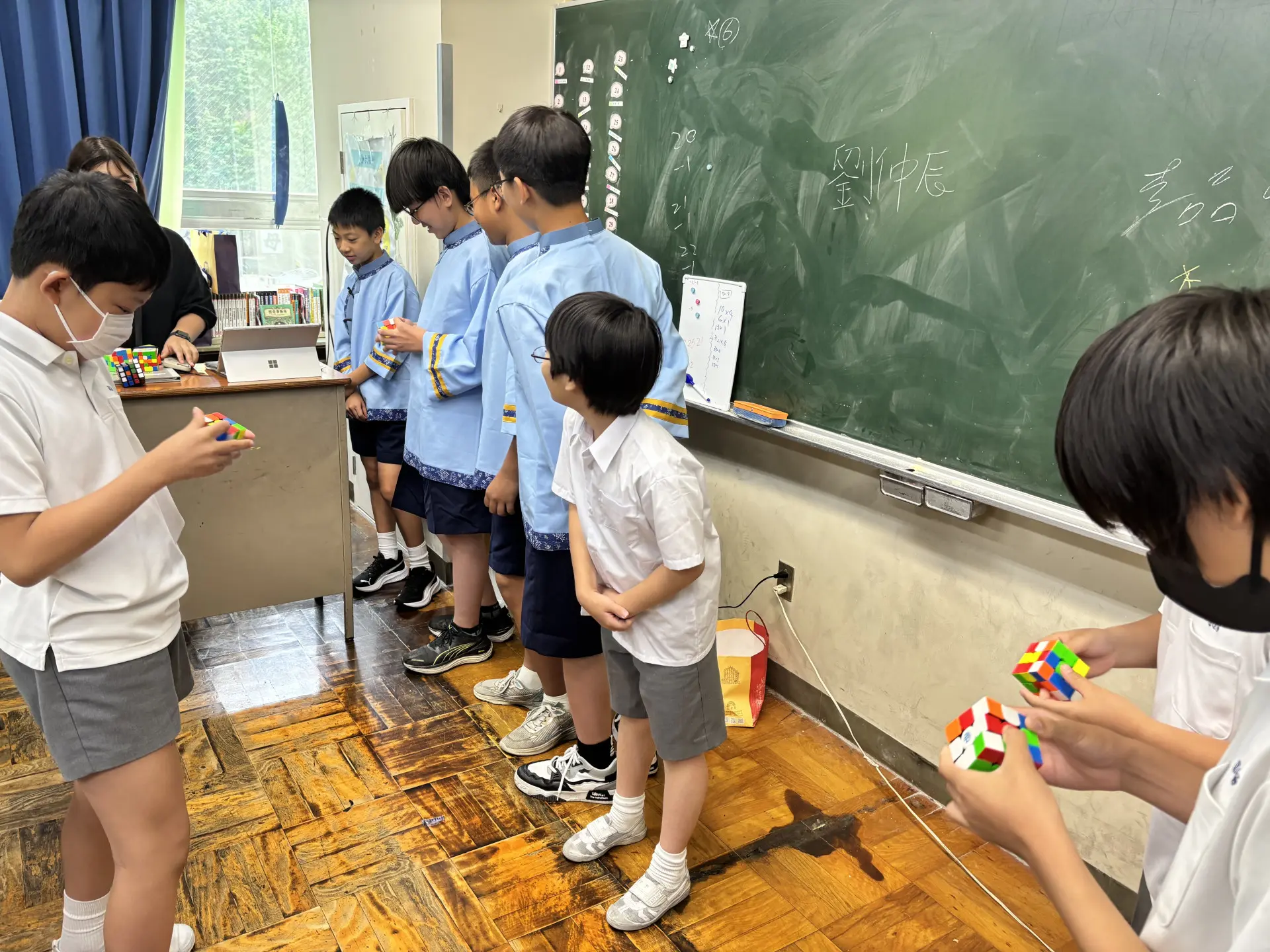客家合唱團孩子入班上課與中華學校孩子一起學習,彼此還比拼魔術方塊。高市客委會提供