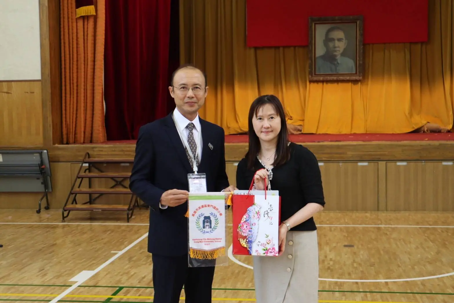 東門國小校長陳永宏致贈紀念品給東京中華學校校長吳育珊。高市客委會提供