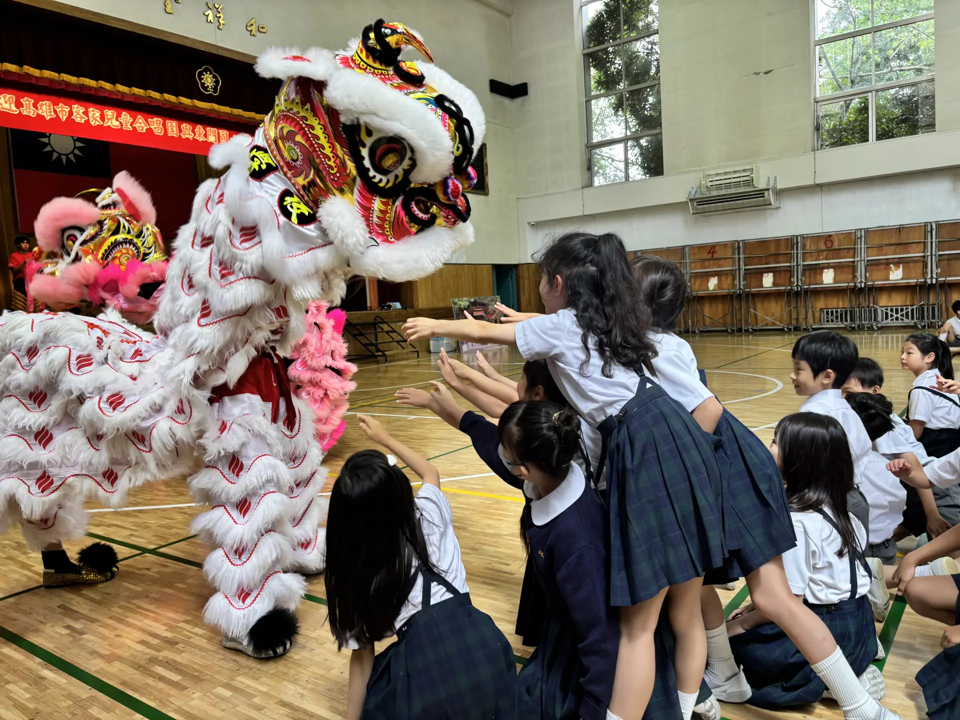 高雄客家兒童合唱團赴日與東京中華學校見習交流,還帶傳統客家方口獅與東京中華學校的東華獅隊同台交流。高市客委會提供