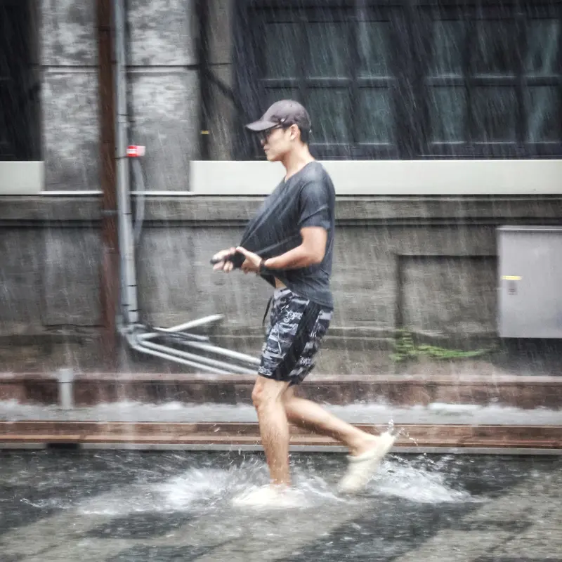 中央氣象署發布豪雨特報，午後對流雲系發展旺盛，易有短延時強降雨，圖為18日下午台北市松山區下起雷雨，民眾在雨中奔走。中央社
