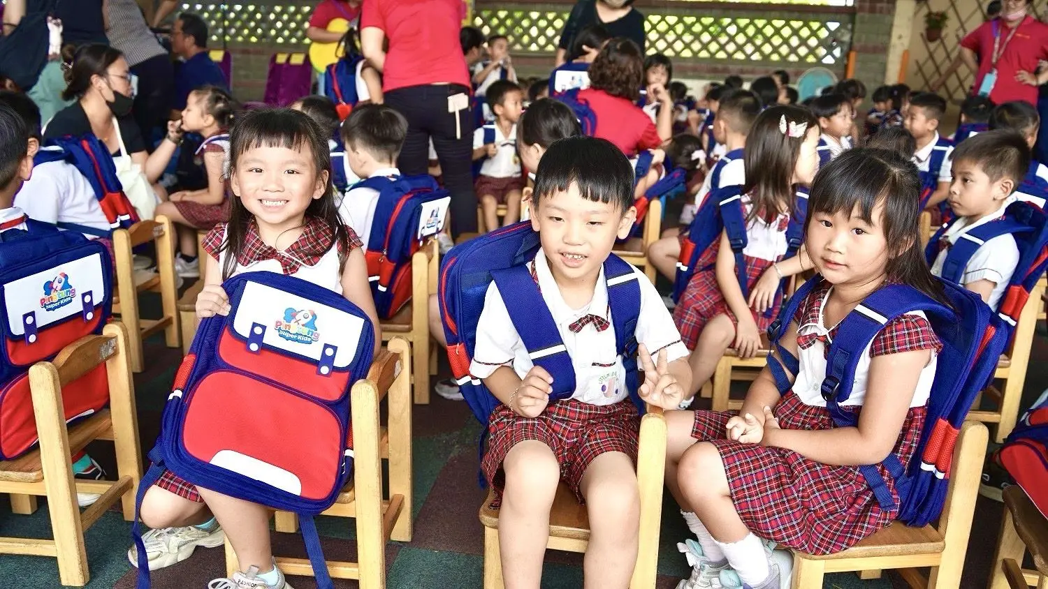 幼兒畢業生興奮地接起新書包，展示給陪同的爸爸媽媽看。屏東縣政府提供