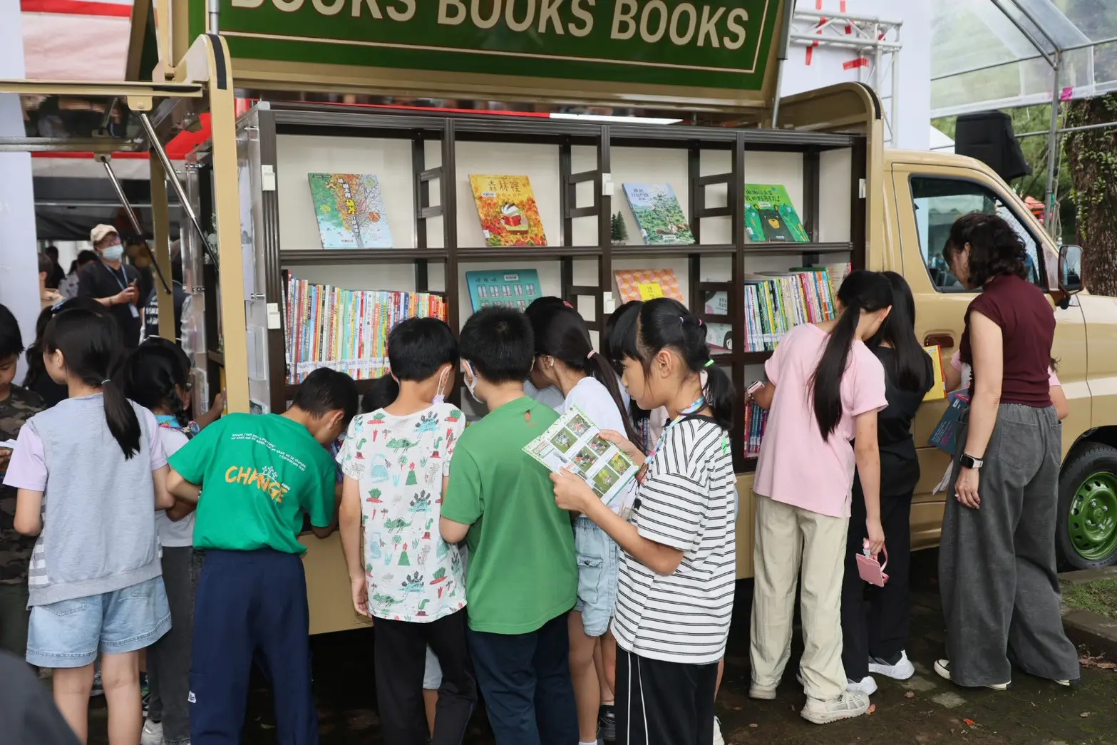 新社行動圖書車，超吸睛新書車打開後，小朋友蜂擁而上拿書閱讀。台中市立圖書館提供