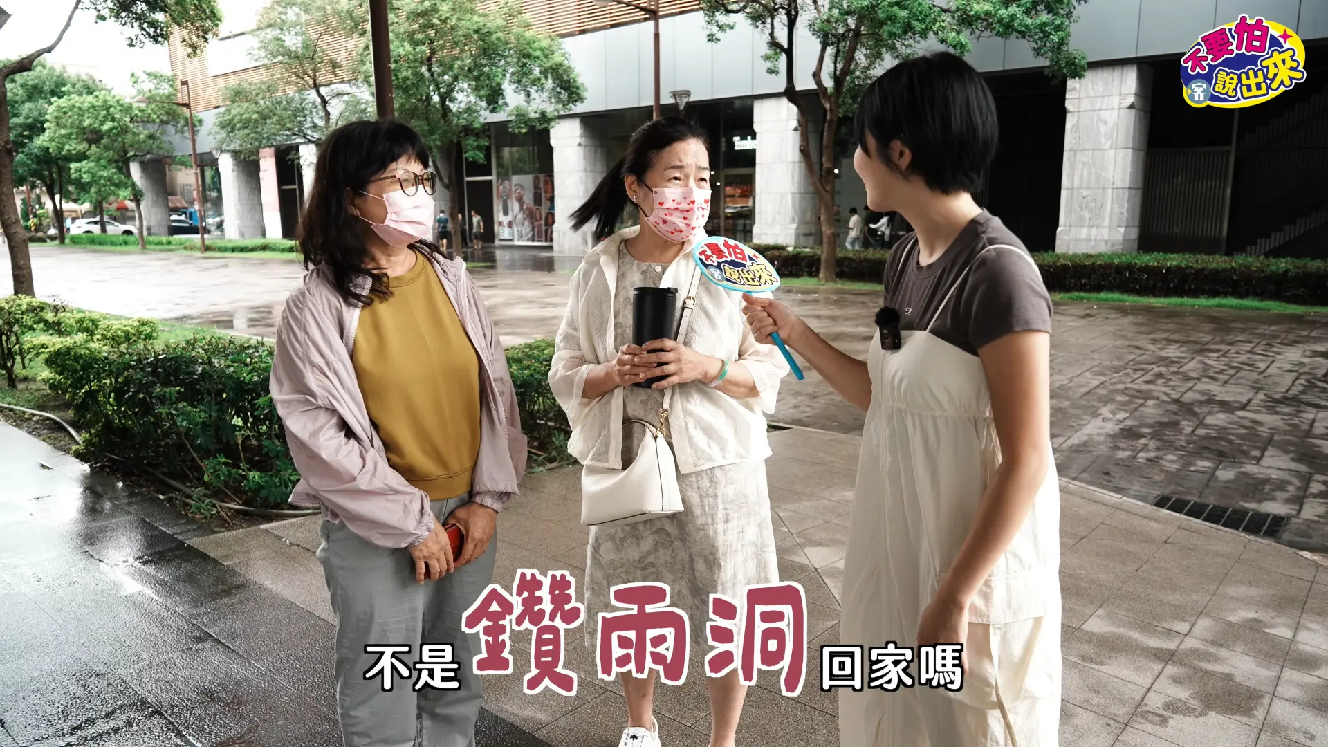 兩位大姐跟主持人說明什麼叫做「鑽雨洞」。客新聞
